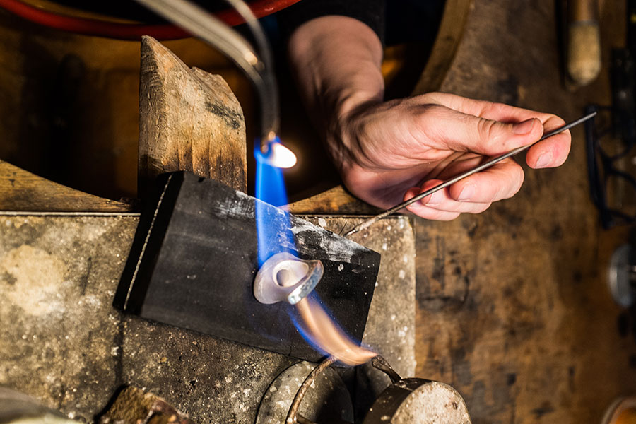 Trauringe mit Feuer am Werktisch einer Goldschmiede